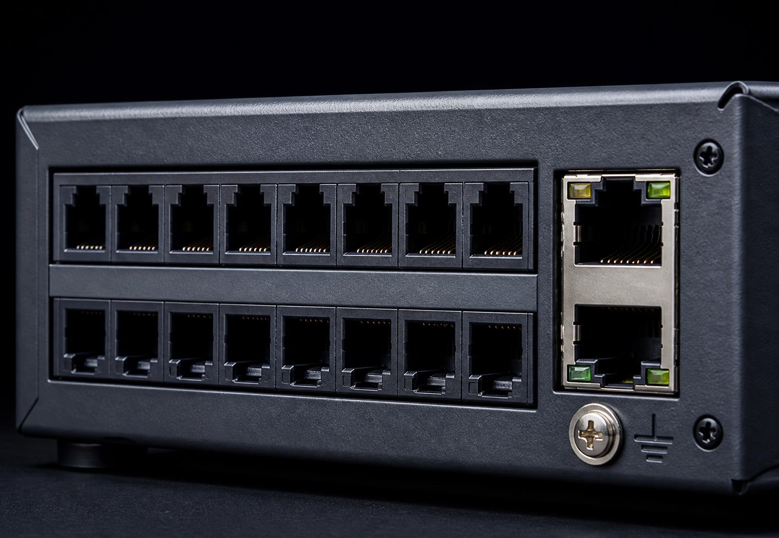 Macro detail of the rear port block: RJ11 FXS and FXO sockets, gigabit Ethernet and grounding point
